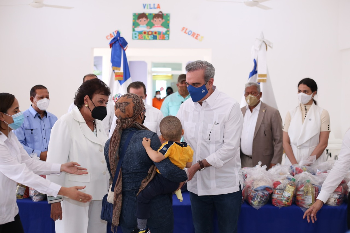 Besaida Santana, directora ejecutiva del Inaipi y el presidente Luis Abinader entregan raciones de alimentos a una familia del CAIPI.