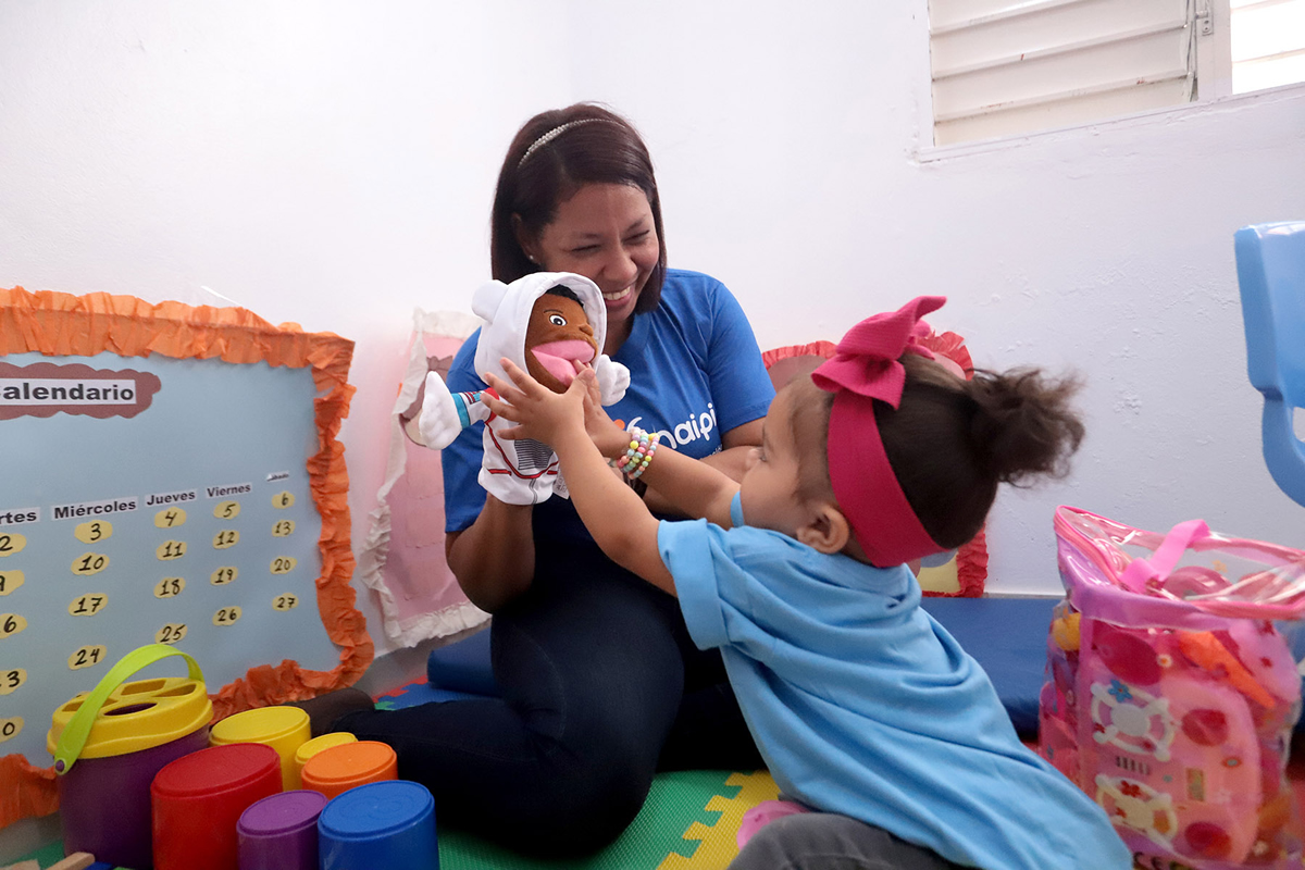 Colaboradora brindando atención a uno de los niños