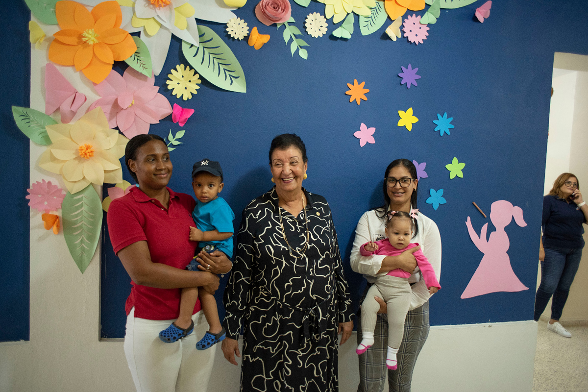 Besaida Santana, directora general del INAIPI, junto a dos madres con sus hijos en el Centro