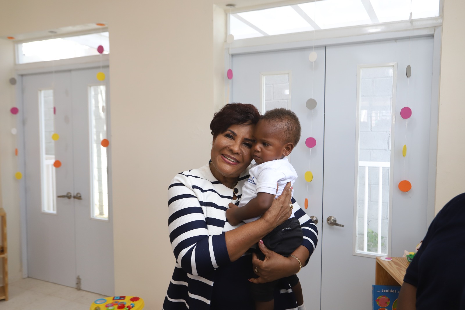 Josefa Castillo Rodríguez, directora ejecutiva del INAIPI con niño del CAIPI en brazos