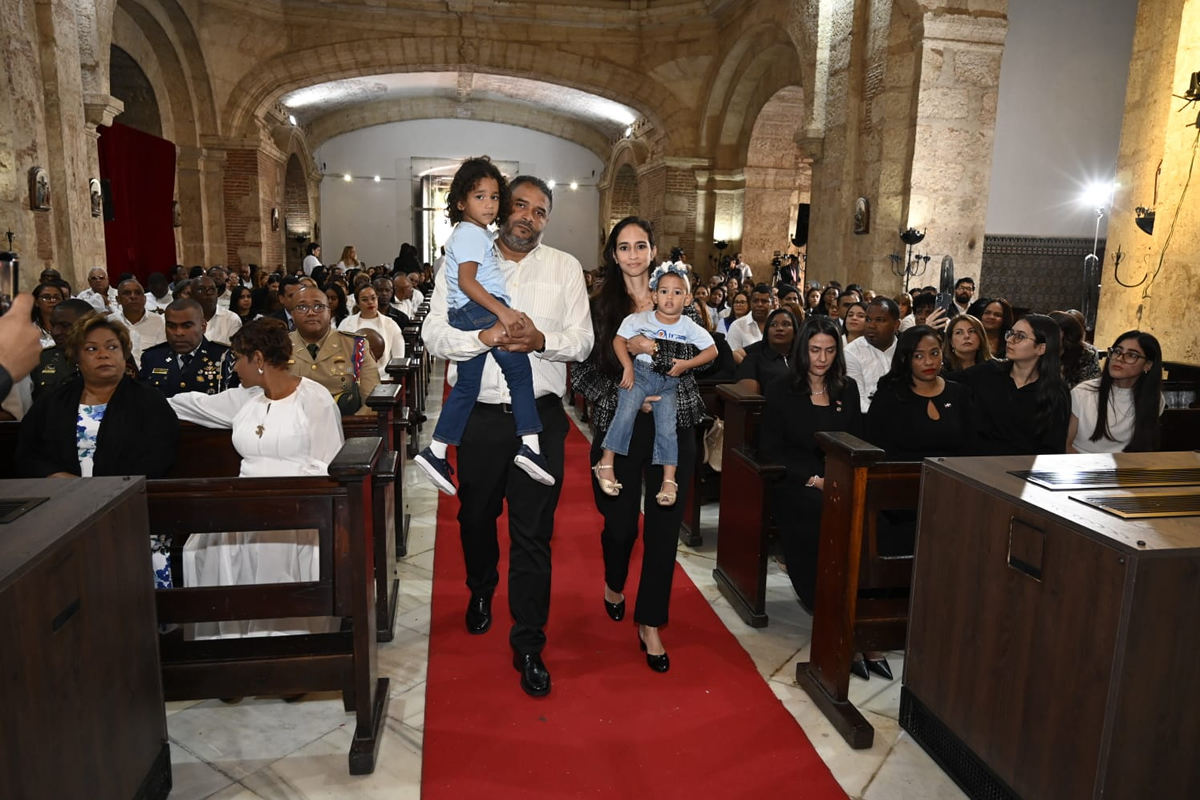 Familia usuaria de los servicios del INAIPI camina hacia el altar de la iglesia para presentar la ofrenda